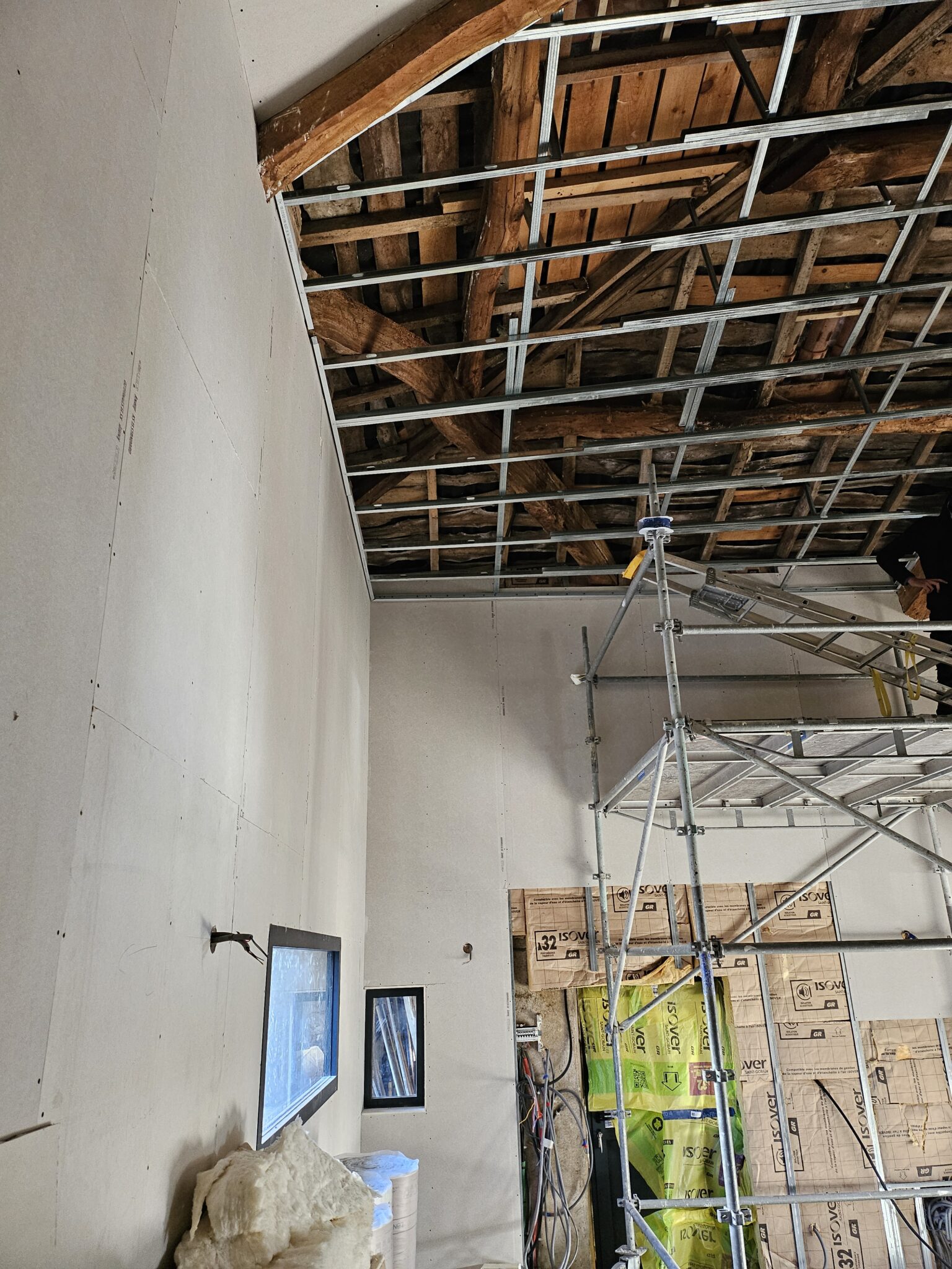 Pose de cloisons sèches en plaques de plâtre et installation d'une structure métallique pour un faux plafond suspendu sous une charpente ancienne en bois par l'EURL Teulières